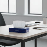A box of Ultrasoft tissue paper with white tissue sheets partially pulled out. The packaging is dark blue with light blue wave patterns and the brand name 'ULTRASOFT' is visible on the front.